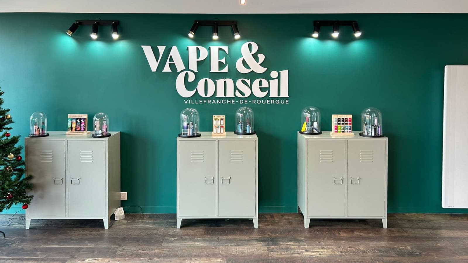 Le mur d'enseigne de la boutique, avec des appareils présentés sous cloches de verre.